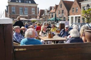 deelnemers seniorenautovakanties op een terras tijdens een autorit