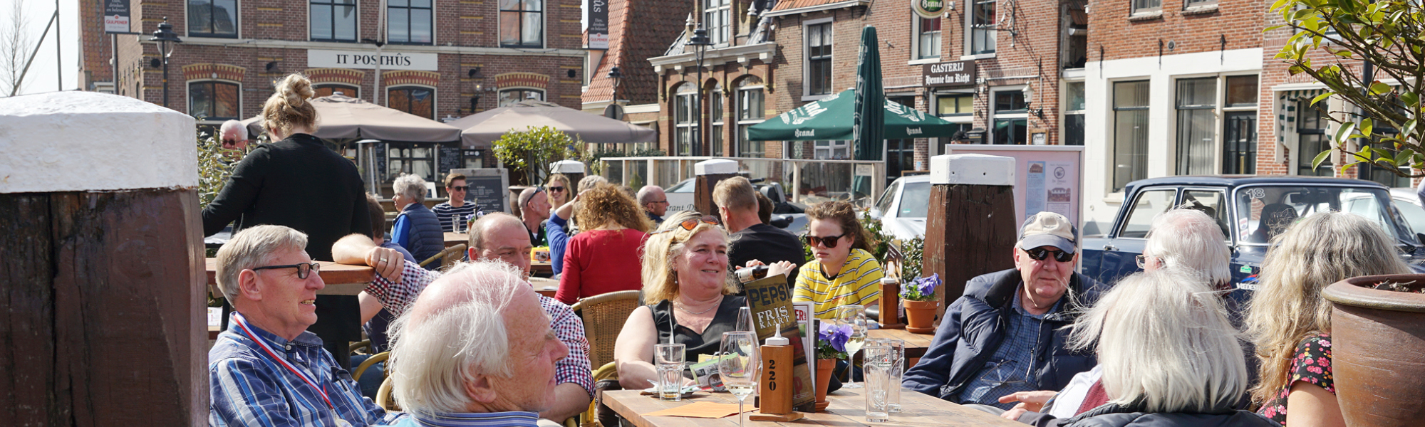 deelnemers seniorenautovakanties op een terras tijdens een autorit uitjes en dagtochten